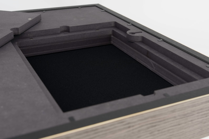 May include: A black wooden box with a hinged lid and a black foam interior. The box is open and the foam is visible.