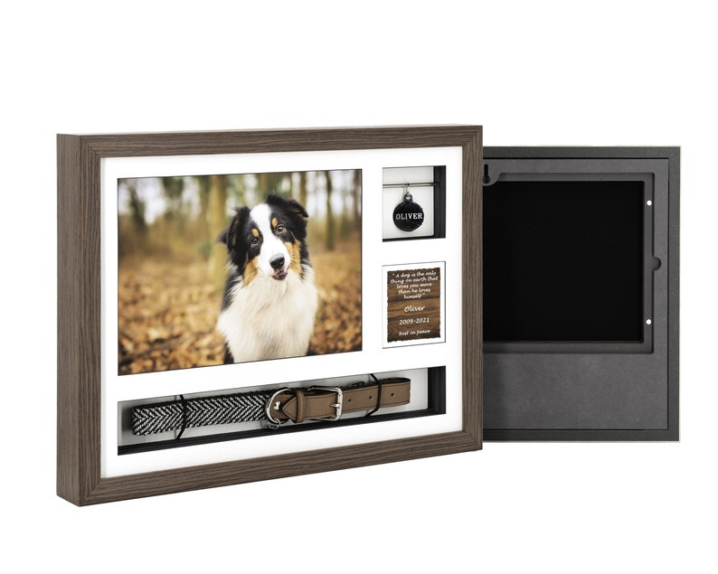Pode incluir: Uma moldura de madeira marrom com um passe-partout branco e uma foto de um c&atilde;o preto e branco. A moldura tem um pequeno compartimento para uma etiqueta de cachorro e um compartimento maior para uma coleira de cachorro. A moldura est&aacute; aberta para revelar um compartimento forrado de veludo preto.