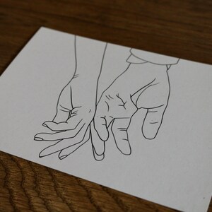 May include: A line drawing of two hands holding each other. The hands are drawn in a simple style, with no details of the fingers or nails.