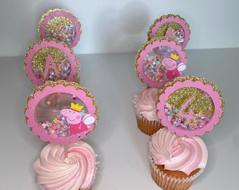 May include: Pink and gold cupcakes with a Peppa Pig character on top. The cupcakes are decorated with pink frosting and gold glitter.