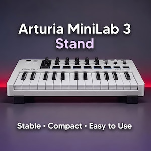 Op de afbeelding: Een wit Arturia MiniLab 3 MIDI-keyboard op een zwarte standaard. De tekst Arturia MiniLab 3 Stand staat boven het keyboard en de tekst Stable • Compact • Easy to Use staat onder het keyboard.