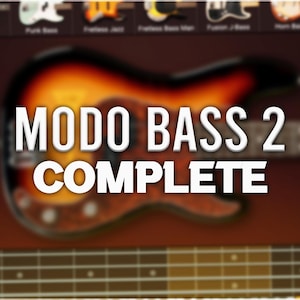 May include: A close-up of a brown and orange electric bass guitar with the text "MODO BASS 2 COMPLETE" on top of it. The guitar is in focus, while the background is blurred.