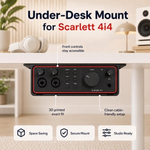 May include: Black under-desk mount for Scarlett 4i4 audio interface. The mount has a red trim and includes front controls, 3D printed design, and a clean cable-friendly setup. The text on the mount reads "Scarlett 4i4".