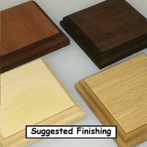 May include: Four wooden display bases in various finishes: light, medium, and dark brown, and natural wood. The bases are square with a layered design. The text "Suggested Finishing" is displayed in a white box at the bottom.