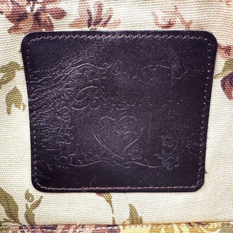 Puede incluir: Un parche de cuero marr&oacute;n con un coraz&oacute;n y un dise&ntilde;o floral. El parche tiene el texto "Forever Love" en relieve.