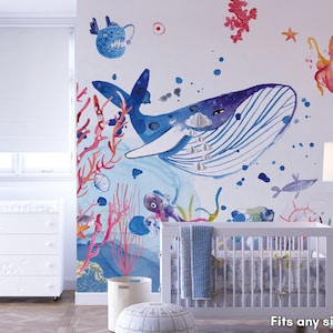 Ocean wallpaper featuring a whimsical underwater scene with a smiling whale, playful octopus, gliding starfish, and various fish among coral reefs, perfect for a nursery or playroom.