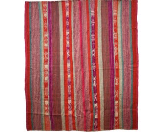 Op de afbeelding: Een kleurrijk geweven tapijt met een gestreept patroon in tinten rood, roze, turquoise en wit.