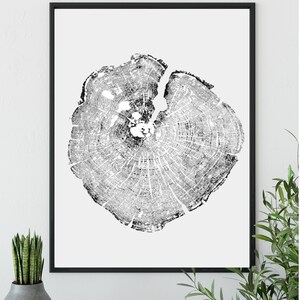 May include: Black and white print of a tree trunk cross section, showing the rings of the tree. The print is framed in a black frame.