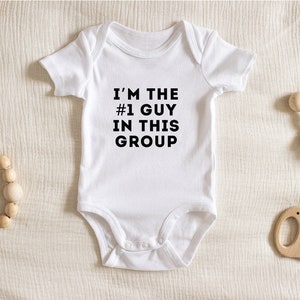 May include: White baby onesie with black text that reads "I'm the #1 guy in this group".