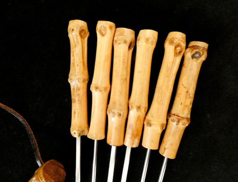 May include: Set of six bamboo skewers with metal tips. The skewers are natural brown and have a smooth finish.