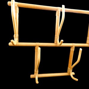 Puede incluir: Un perchero de madera con cinco ganchos. El perchero est&aacute; hecho de bamb&uacute; natural y tiene un color marr&oacute;n claro.