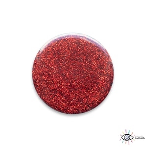 Peut inclure: Un bouton rond rouge pailleté.