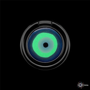 May include: A black phone ring holder with a blue and green evil eye design.