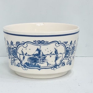 Puede incluir: Cuenco de cer&aacute;mica color crema con escena n&aacute;utica azul y detalles florales. El cuenco tiene un borde azul y un panel decorativo con veleros sobre el agua. Una pieza decorativa cl&aacute;sica.