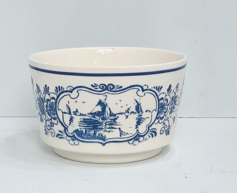 Puede incluir: Cuenco de cer&aacute;mica color crema con escena n&aacute;utica azul y detalles florales. El cuenco tiene un borde azul y un panel decorativo con veleros sobre el agua. Una pieza decorativa cl&aacute;sica.