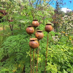 Escultura de jardín con cabezas de amapola de metal.