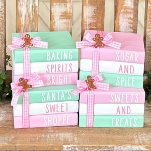 May include: Stack of five pink and green painted wooden blocks with gingerbread man accents. The blocks are decorated with white text that reads "Baking Spirits Bright", "Santa's Sweet Shoppe", "Sugar and Spice", "Sweets and Treats".