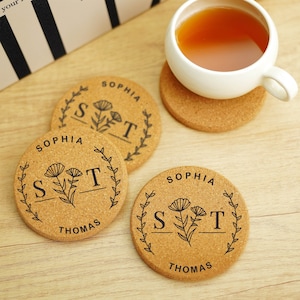 Pode incluir: Três  tábuas de cortiça com um design floral e os nomes "Sophia" e "Thomas" impressos nelas. As tábuas são redondas e têm uma cor de cortiça natural.