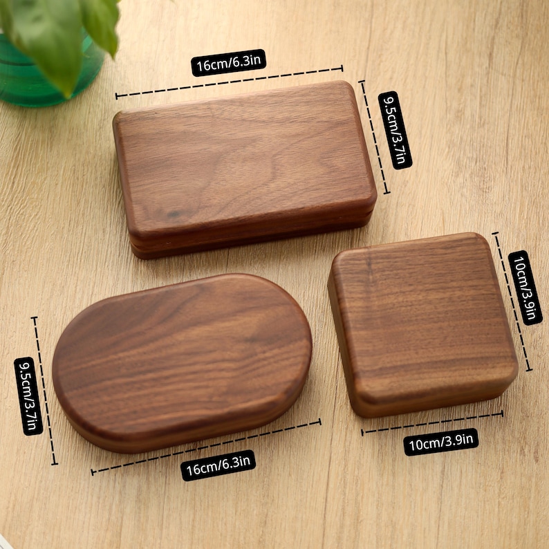 May include: Three wooden boxes in different shapes: a rectangle (6.3in x 3.7in), an oval (6.3in x 3.7in), and a square (3.9in x 3.9in). The boxes are made of a dark wood with visible grain. The boxes are on a light brown surface.