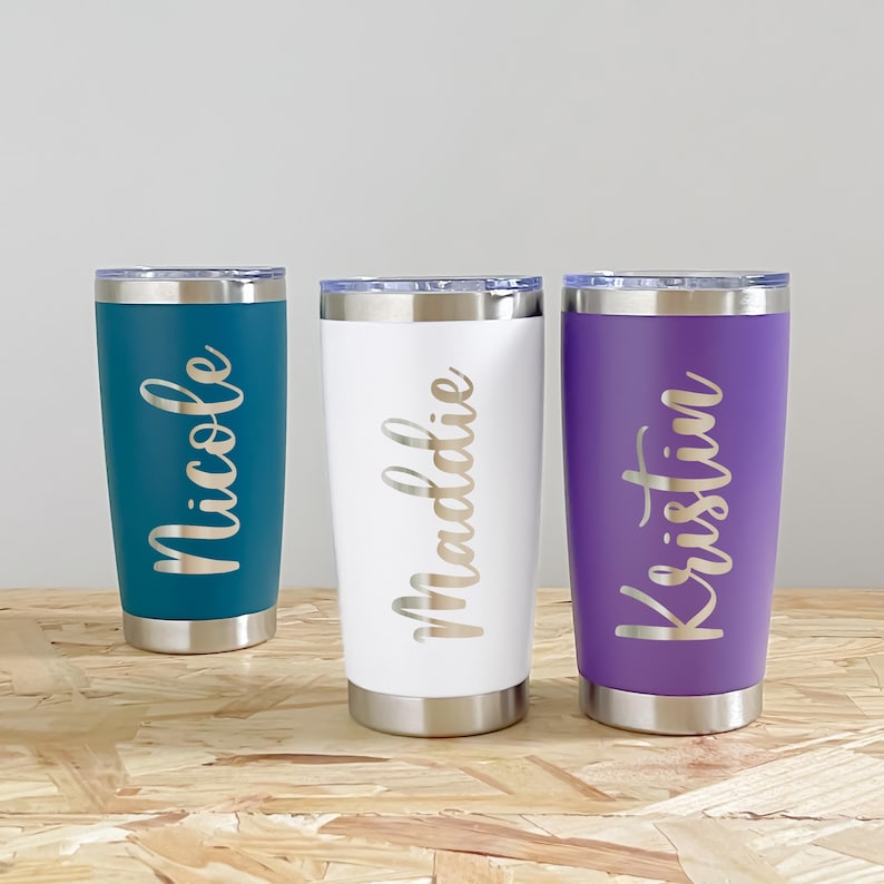 May include: Three personalized tumblers in teal, white, and purple. Each tumbler has a silver lid and base. The teal tumbler is inscribed with "Nicole", the white tumbler with "Maddie", and the purple tumbler with "Kristin".