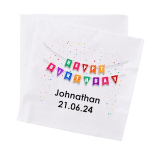May include: White paper napkin with a colorful banner that reads "HAPPY BIRTHDAY". The napkin has the name "Johnathan" and the date "21.06.24" printed in black. Confetti is scattered around the banner.