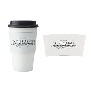 Pu&ograve; includere: Tazza da caff&egrave; di carta bianca con coperchio nero e manicotto abbinato. La tazza e il manicotto presentano il testo "NOVEMBER 18, 2024" e "OLIVE & MAGIE" con un design a ramo d'ulivo. La tazza &egrave; progettata per bevande calde.