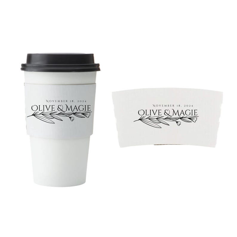 Pu&ograve; includere: Tazza da caff&egrave; di carta bianca con coperchio nero e manicotto abbinato. La tazza e il manicotto presentano il testo "NOVEMBER 18, 2024" e "OLIVE & MAGIE" con un design a ramo d'ulivo. La tazza &egrave; progettata per bevande calde.