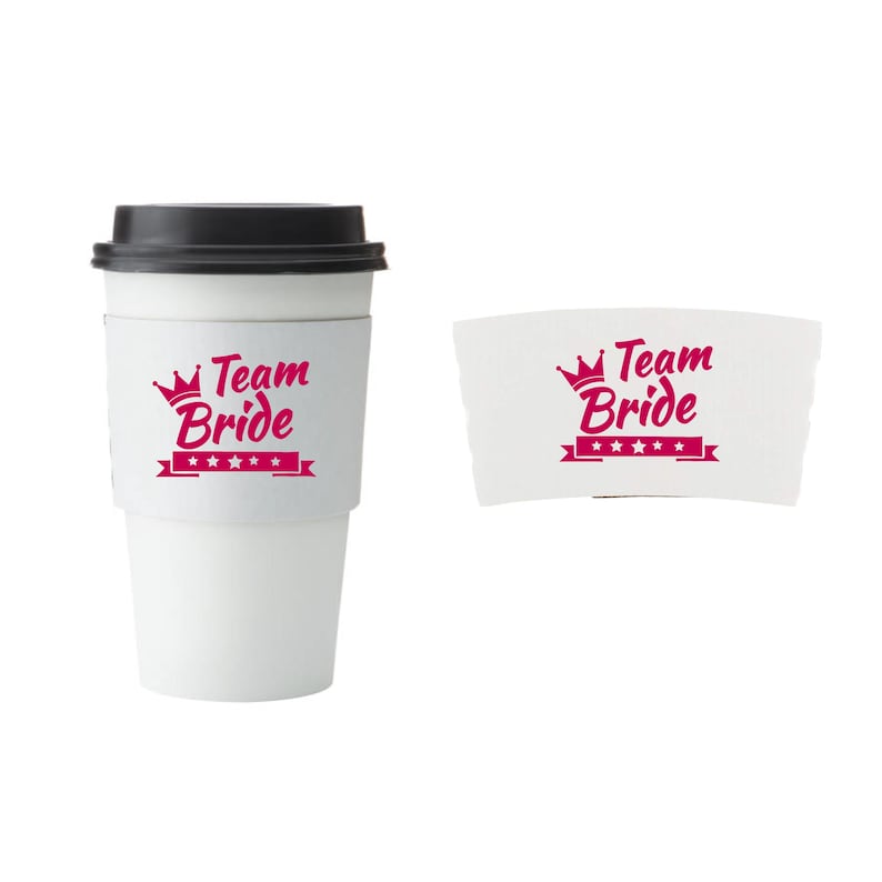 Pu&ograve; includere: Una tazza da viaggio bianca con coperchio nero e manicotto bianco. Il manicotto e un manicotto separato mostrano la scritta "Team Bride" in rosa, con una corona e stelle. La tazza &egrave; per un addio al nubilato.