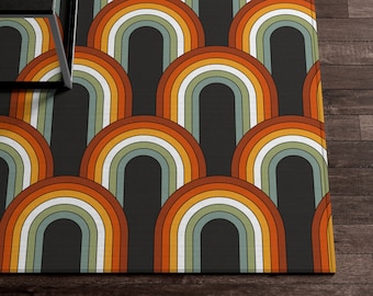 May include: A colorful rug with a geometric pattern of overlapping arches in shades of orange, yellow, green, and white on a dark brown background.