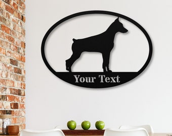 Könnte beinhalten: Schwarze Metallsilhouette eines Dobermann Pinschers in einem ovalen Rahmen mit dem Text "Your Text" darunter.