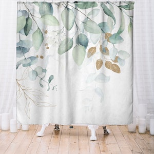 May include: A white shower curtain featuring a watercolor design of eucalyptus leaves in shades of green and blue, with accents of gold glitter. The leaves are arranged in a delicate, flowing pattern.