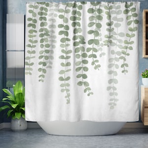 May include: White shower curtain with a watercolor design of green leafy vines hanging down. The vines are a light green and a darker green.