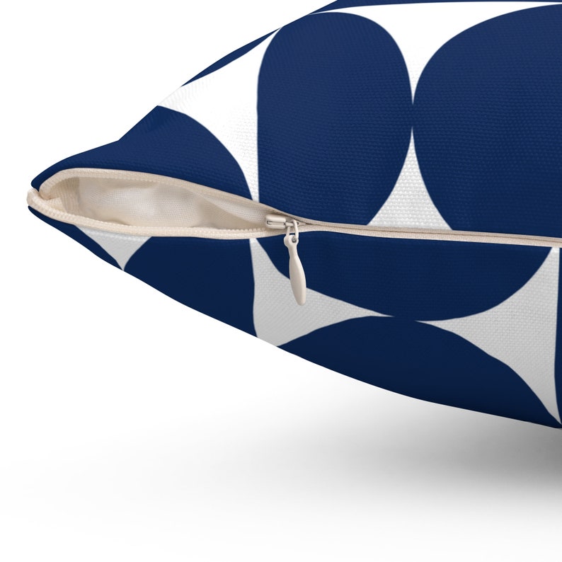 May include: A navy blue and white geometric patterned cushion with a zip closure.