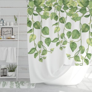 May include: White shower curtain with a green leafy vine pattern. The shower curtain is hanging in a bathroom with a white tiled wall and a white shelf with towels and toiletries.