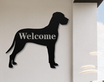 May include: Black metal silhouette of a Great Dane dog with the word "Welcome" cut out of the body. The silhouette is mounted on a white wall.