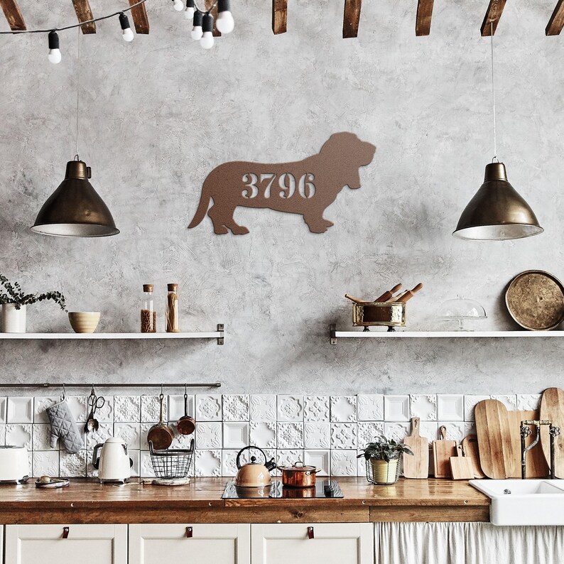 May include: A brown metal wall art piece in the shape of a dog, with the number "3796" cut out in the center. The dog is in a standing position. The art is mounted on a gray wall in a kitchen setting.