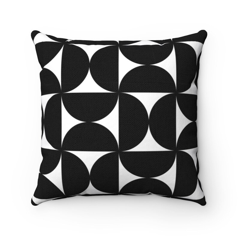 May include: Square throw pillow with a black and white geometric pattern. The design features a repeating pattern of black semi-circles against a white background. The pillow has a textured appearance and is likely made of fabric.