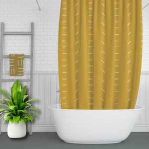May include: A yellow shower curtain with a white geometric pattern. The curtain is hanging in a bathroom with a white bathtub.