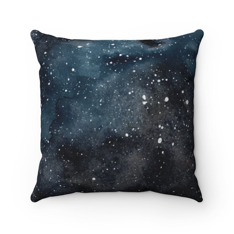 May include: A dark blue throw pillow with a white watercolor galaxy print. The pillow is soft and comfortable, perfect for adding a touch of space to your home decor.