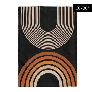 May include: A black and brown geometric throw blanket with a pattern of concentric circles and arches. The blanket is 60 inches by 80 inches.