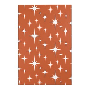 May include: A seamless pattern featuring white starbursts on a burnt orange background.