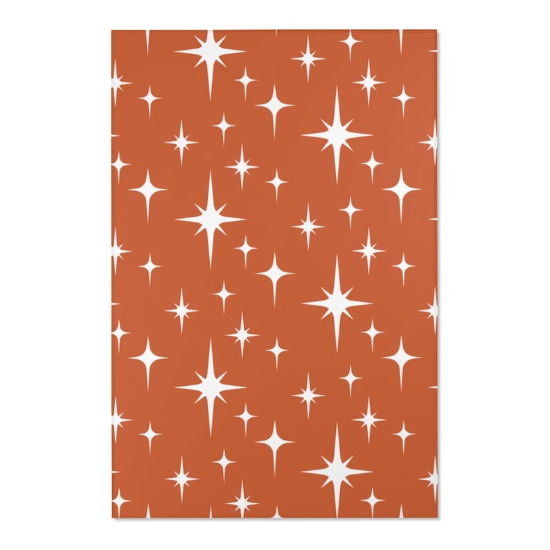 May include: A seamless pattern featuring white starbursts on a burnt orange background.