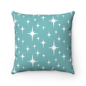 May include: A teal blue throw pillow with a white starburst pattern.