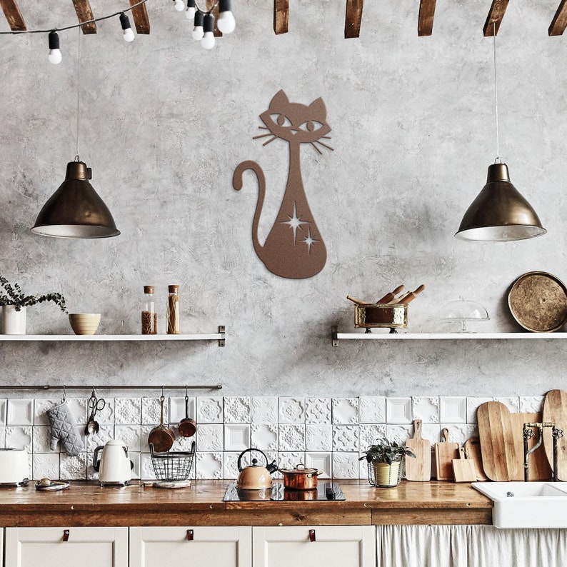 May include: A brown wooden cat silhouette wall decor with a star design. The cat is sitting on a gray wall in a kitchen setting.