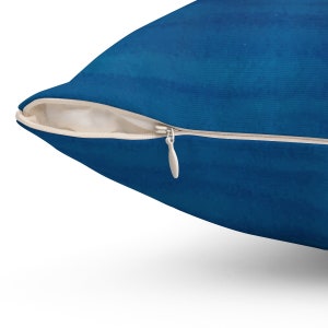 Puede incluir: Una almohada azul con cierre de cremallera. La almohada est&aacute; hecha de una tela suave y texturizada.