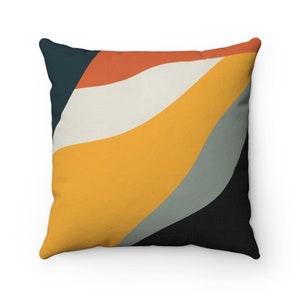 May include: A square throw pillow with a geometric pattern in shades of orange, yellow, gray, and black. The pattern features curved lines and abstract shapes.