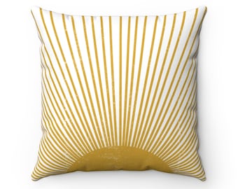 May include: A white throw pillow with a yellow sunburst design. The sunburst is made up of thin yellow lines radiating out from a yellow circle in the center.