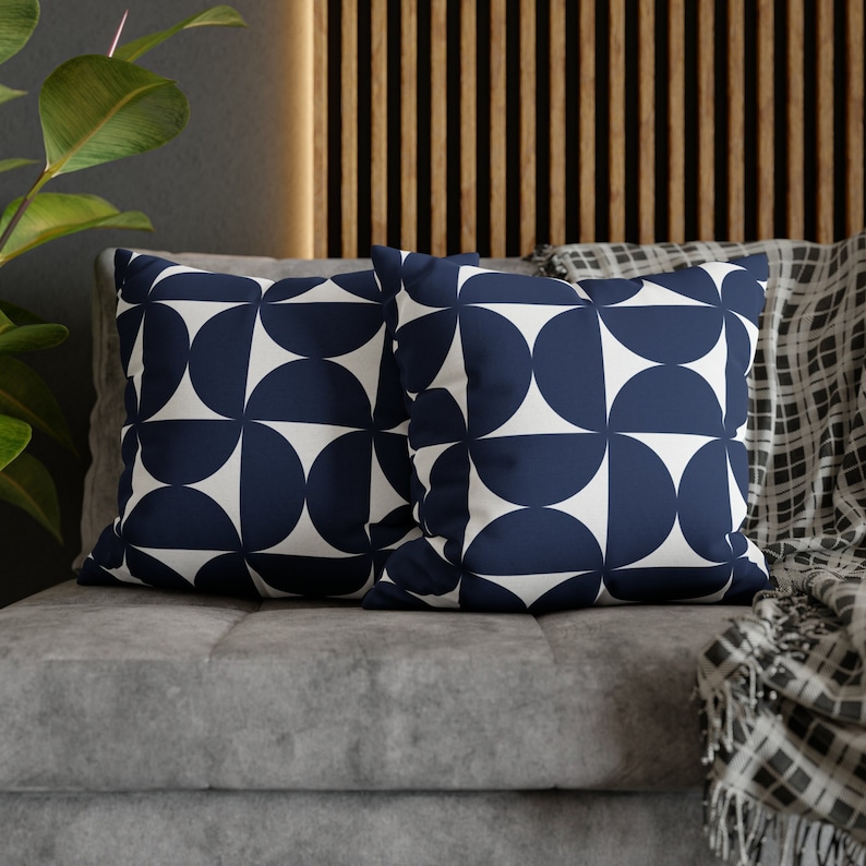 May include: Two decorative throw pillows with a geometric pattern of navy blue semi-circles on a white background.