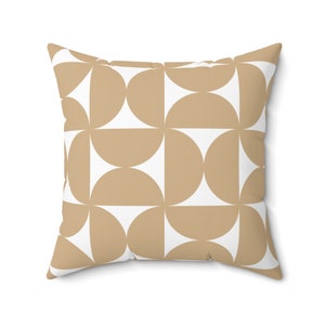 May include: Square throw pillow with a geometric pattern. The design features alternating tan and white semi-circles arranged in a grid. The pillow has a soft, inviting appearance, suitable for home decor.