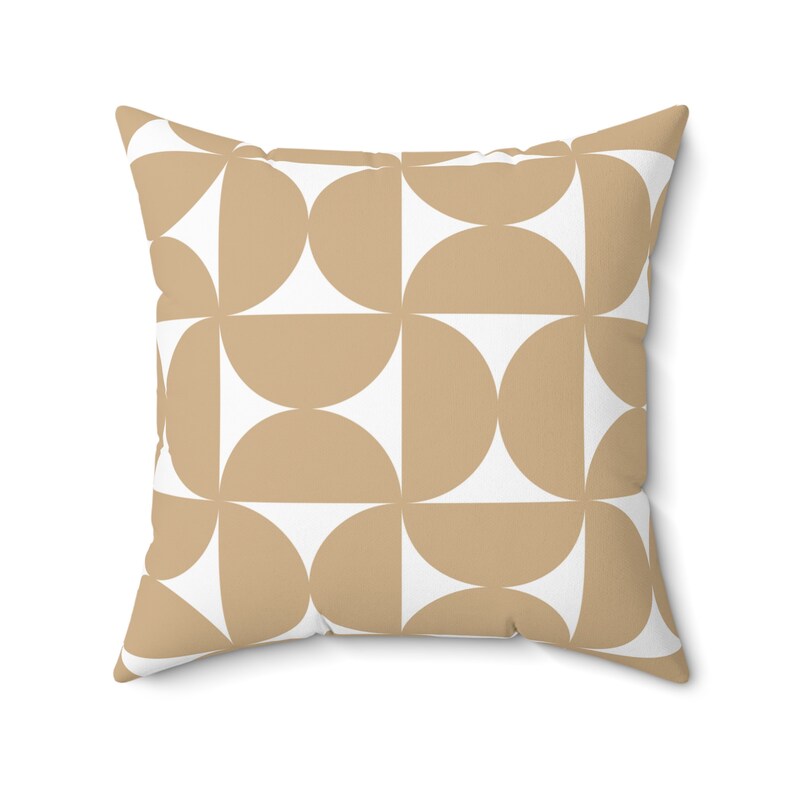 May include: Square throw pillow with a geometric pattern. The design features alternating tan and white semi-circles arranged in a grid. The pillow has a soft, inviting appearance, suitable for home decor.